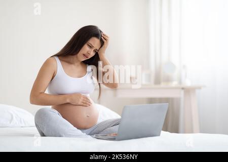 Femme enceinte malade ayant un appel vidéo avec un médecin à la maison Banque D'Images