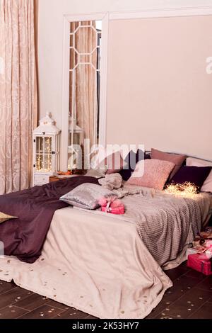 Grand lit avec oreillers dans la chambre. Intérieur moderne rose Banque D'Images