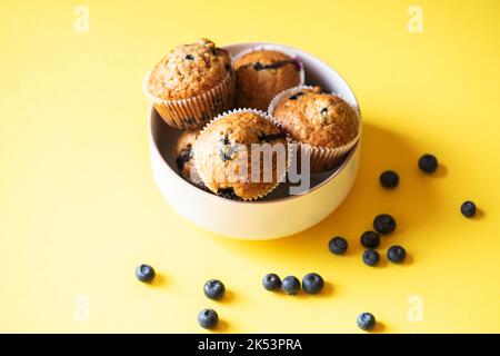 Muffins aux myrtilles servis dans un bol sur fond jaune. Vue de dessus. Banque D'Images