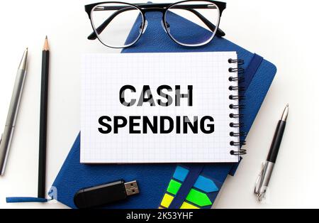 Le texte des dépenses en espèces est écrit sur un bloc-notes avec un stylo et un graphique Banque D'Images