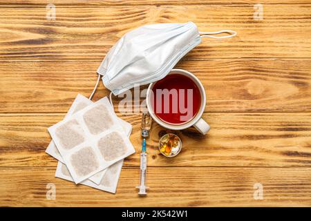 Emplâtres à la moutarde avec médicaments, masque et tasse de thé sur fond de bois Banque D'Images