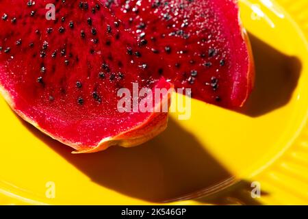 pitaya rose sur une assiette jaune Banque D'Images