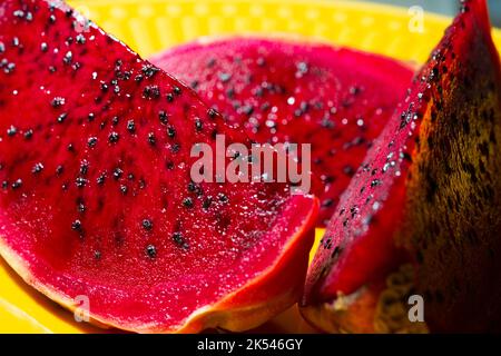 pitaya rose sur une assiette jaune Banque D'Images