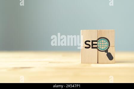 SEO, concept de classement d'optimisation de Search Engine. Stratégie de marketing numérique de promouvoir le trafic vers le site Web. Cubes en bois avec icône de loupe an Banque D'Images
