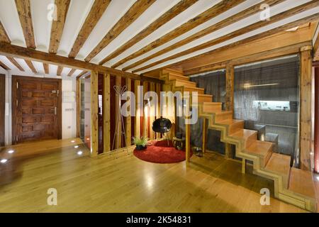 Salon avec escalier en bois dans une maison en duplex avec porte avant lambrissée en bois Banque D'Images