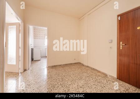 Hall vide avec ancien sol en terrazzo et charpenterie blanche et accès à plusieurs chambres Banque D'Images