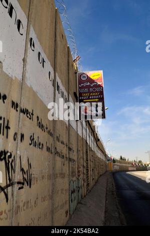 Des publicités pendues sur le mur-barrière construit par Israël en Cisjordanie, en Palestine. Banque D'Images