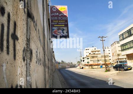 Des publicités pendues sur le mur-barrière construit par Israël en Cisjordanie, en Palestine. Banque D'Images