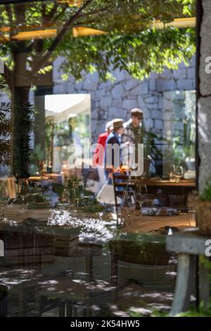 Fenêtres en verre reflétant les personnes marchant dans la nature Banque D'Images