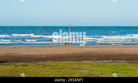 Banc vide sur le rivage d'une mer de tempête Banque D'Images