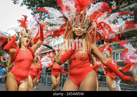 Les danseurs de samba sourient en costumes étincelants, Notting Hill Carnival, Londres, Royaume-Uni Banque D'Images