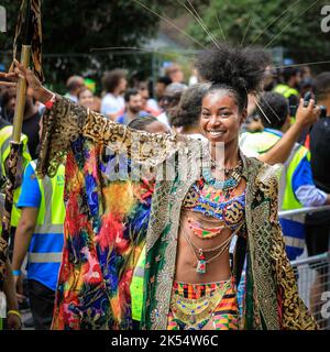 Une participante en costume coloré le long de la route, Notting Hill Carnival, Londres, Royaume-Uni Banque D'Images