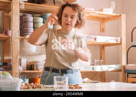 Femme en bois naturel sûr sur le bureau, style écologique. Perles de cerclées. Jouet de dentition avec décoration de ferraillement de cercueil. Travail de fabrication à la main de Banque D'Images