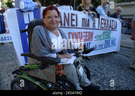 Un activiste en fauteuil roulant se tient avec les retraités pour demander une augmentation des pensions et des mesures contre l'augmentation des coûts énergétiques. Banque D'Images