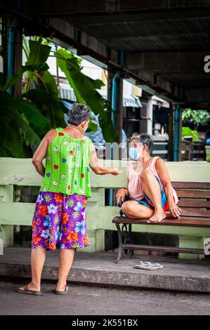 Deux femmes thaïlandaises bavardent dans les rues étroites et les ruelles de la région de Ruamrudee, près du parc Lumpini Bangkok Thaïlande. Banque D'Images