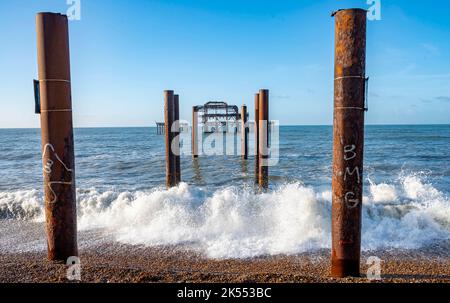 Brighton UK 6th octobre 2022 - les vagues se roulent par la jetée ouest de Brighton sur une belle matinée ensoleillée mais froide : crédit Simon Dack / Alamy Live News Banque D'Images