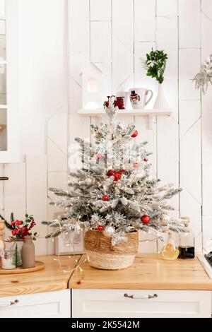 Arbre de Noël dans une cuisine blanche dans un intérieur lumineux Banque D'Images