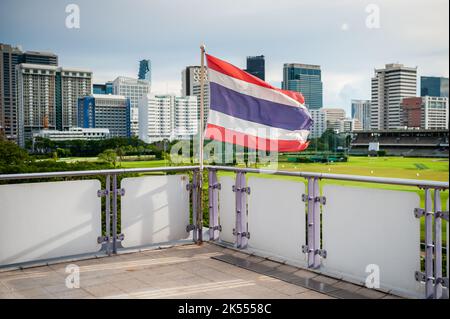 Le drapeau de la Thaïlande vole sur la plate-forme de la station de train aérien de transit de masse BTS de Ratchadamri, Bangkok, Thaïlande. Banque D'Images