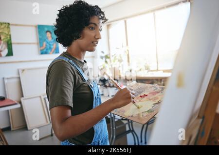 Peinture, art et création avec une femme peintre ou artiste travaillant sur une toile dans son atelier ou studio. Artistique, créativité et art avec un jeune Banque D'Images