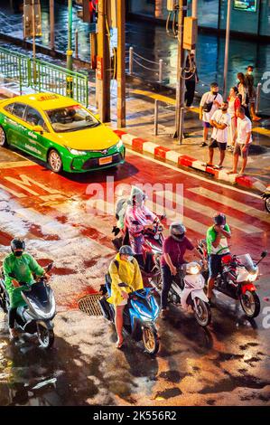 La circulation vous attend au passage à Zèbre, sur la célèbre route animée Asoke Montri Carrefour routier à Bangkok, en Thaïlande, lors d'une soirée humide et pluvieuse. Banque D'Images