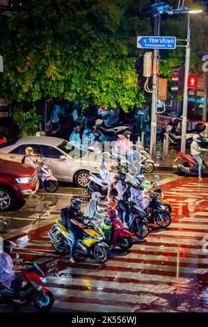 Des voitures et des vélos attendent à la traversée piétonne de Ratchadaphisek Rd Bangkok Thaïlande. Banque D'Images