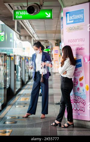 Des femmes d'affaires thaïlandaises élégantes et élégantes attendent à la gare Siam BTS SKY train pour leur train à Bangkok Thaïlande. Banque D'Images