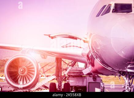 Détail de l'avion à l'entrée du terminal avant le décollage - Voyage concept et flâner dans le monde à l'aéroport international au coucher du soleil - Vintage marsala f Banque D'Images