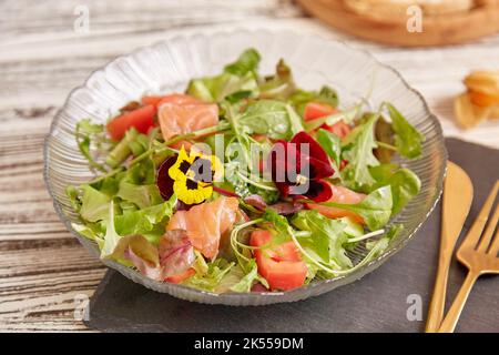 Salade pescétarienne saine avec saumon fumé, légumes, légumes verts et fleurs comestibles Banque D'Images