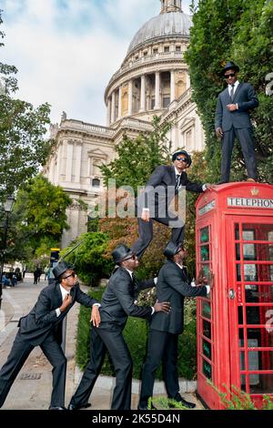 Bilal Musa Huka, Rashid Amini Kulembwa, Seif Mohamed Mlevi, Peter Mnyamosi Obunde et Mohamed Salim Mwakidudu AKA les frères Blues noirs montrent leurs compétences acrobatiques sur et dans une boîte téléphonique rouge de londres contre le fond de la cathédrale St Paul. Les Black Blues Brothers sont une troupe d'acrobates qui se sont produits pour le Pape François au Vatican, à la famille royale britannique et au Royal Variety Show. Les Black Blues Brothers font une tournée au Royaume-Uni avec leur spectacle qui est un hommage acrobatique au légendaire film culte. Les frères Black Blues ont utilisé une légendaire Red Phone Box de Londres pour un p Banque D'Images