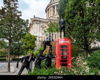 Bilal Musa Huka, Rashid Amini Kulembwa, Seif Mohamed Mlevi, Peter Mnyamosi Obunde et Mohamed Salim Mwakidudu AKA les frères Blues noirs montrent leurs compétences acrobatiques sur et dans une boîte téléphonique rouge de londres contre le fond de la cathédrale St Paul. Les Black Blues Brothers sont une troupe d'acrobates qui se sont produits pour le Pape François au Vatican, à la famille royale britannique et au Royal Variety Show. Les Black Blues Brothers font une tournée au Royaume-Uni avec leur spectacle qui est un hommage acrobatique au légendaire film culte. Les frères Black Blues ont utilisé une légendaire Red Phone Box de Londres pour un p Banque D'Images