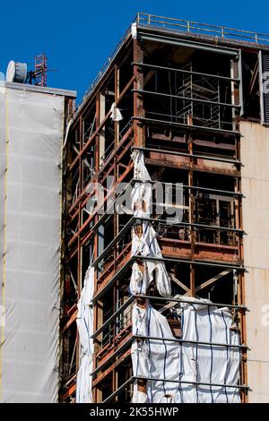 Coin d'une ancienne usine ou usine industrielle. Le mur a été enlevé et le bâtiment est en réparation. Un revêtement en plastique est visible. Banque D'Images