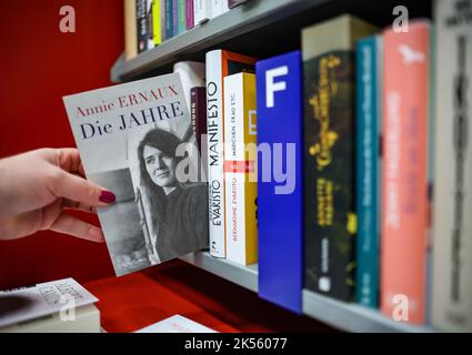 Leipzig, Allemagne. 06th octobre 2022. Une femme retire le livre d'Annie Ernaux « les années » dans une librairie de Leipzig. L'écrivain française Annie Ernaux reçoit le prix Nobel de littérature. Credit: Jan Woitas/dpa/Alay Live News Banque D'Images