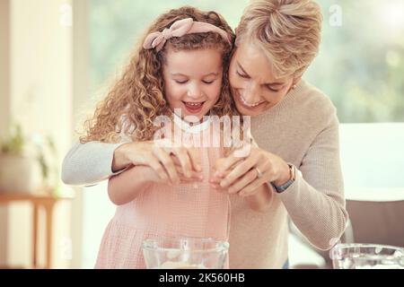 Les enfants, la famille et la pâtisserie avec une fille apprenant et grand-mère cuisinant dans une cuisine de leur maison ensemble. Enfants, nourriture et ingrédients avec un aîné Banque D'Images
