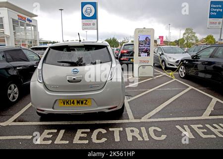 Deux véhicules électriques se chargeant aux points de recharge gratuits de Tesco utilisant 100 % d'électricité renouvelable à Quedgely Gloucester, Royaume-Uni Banque D'Images