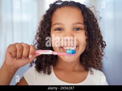 Fille, brosse et sourire avec des dents pour les soins dentaires, les soins et l'hygiène propre dans les soins buccaux frais à la maison. Portrait d'une heureuse femme enfant, visage et Banque D'Images