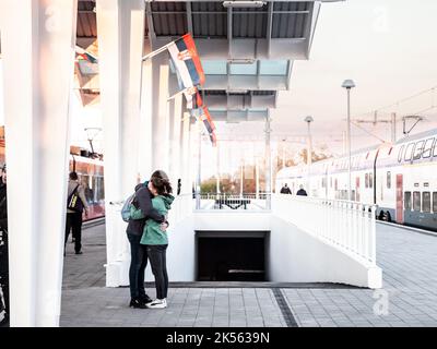 Photo d'un couple fait de petite amie et petit ami blanc caucasien échangeant un dernier baiser dans la gare de Novi Sad, en Serbie, en attendant un train o Banque D'Images