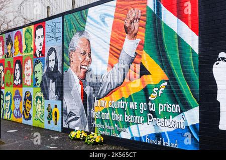 Belfast, Irlande du Nord. 7th décembre 2013 - les hommages floraux sont laissés à la fresque de Mandela après la mort de Nelson Mandela le 5th décembre. Banque D'Images