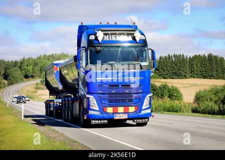 Le camion asphalté Blue Volvo Mikkola, devant la remorque à cassette, livre la charge le long de la route en été. Salo, Finlande. 25 août 2022. Banque D'Images