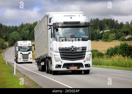 Deux poids lourds blancs, Mercedes-Benz Actros et Scania, tracent des semi-remorques sur l'autoroute un jour d'été. Salo, Finlande. 25 août 2022. Banque D'Images