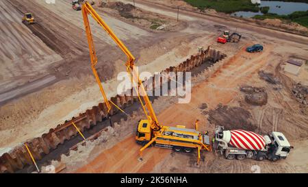 Grue de camion, mélangeur de béton de camion et autres machines travaillant sur un chantier de construction de routes à Varsovie, Pologne. Vue de dessus de drone. Photo de haute qualité Banque D'Images