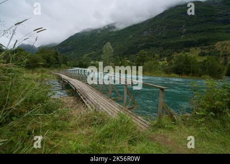 Passerelle en bois et plate-forme de pêche traversant un affluent de la rivière Oldeelva à Olden, en Norvège. Le panneau en bois indique « ELVEBAKKANE ». Banque D'Images