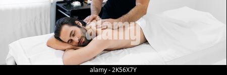massage pour hommes. Bel homme passer du temps au spa et obtenir le massage à l'huile et l'aromathérapie Banque D'Images