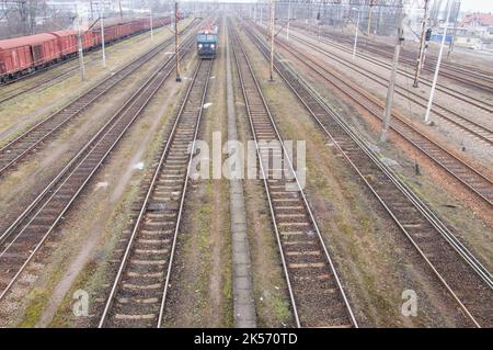 Locomotives électriques, wagons, infrastructure ferroviaire sur un ciel nuageux jour d'automne. Banque D'Images