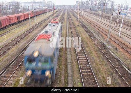 Locomotives électriques, wagons, infrastructure ferroviaire sur un ciel nuageux jour d'automne. Banque D'Images