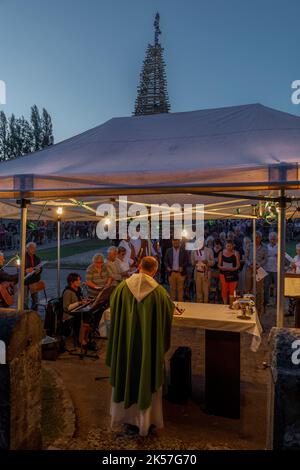 France, Eure, la Haye-de-Routot, feu de joie traditionnel de Saint-clair, une pyramide de bois sec de 15 mètres de haut est érigée, sur la place du village, devant l'église et ses yews vieux de mille ans. Une masse et une bénédiction précèdent l'incendie du pieu, si la croix au sommet ne brûle pas, c'est un bon signe pour les 12 mois à venir, ramenant à la maison un morceau de bois charré, appelé brandon, protégera la maison contre la foudre Banque D'Images