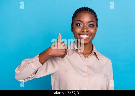 Photo d'une femme d'affaires joyeuse excitée montrant le pouce vers le haut recommander son entreprise isolée sur fond bleu de couleur Banque D'Images