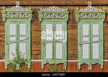Vieille fenêtre en bois peint blanc vert, porte. Architecture sculptée, volets fermés. Ulan-Ude, Russie. Banque D'Images