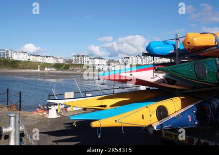 Kayaks colorés stockés côté port à Port Erin, île de Man. Banque D'Images