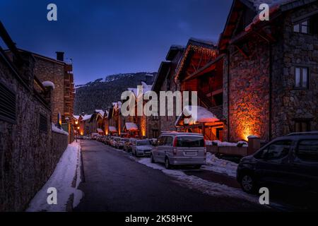 Maisons et appartements modernes en pierre éclairés par des lumières de rue dans le village d'El Tarter au crépuscule ou la nuit tombent dans les Pyrénées, Grandvalira, Andorre Banque D'Images