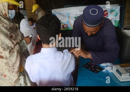 Peshawar, Khyber Pakhtunkhwa, Pakistan. 6th octobre 2022. Un étudiant reçoit un vaccin contre la fièvre typhoïde au cours d'une campagne de vaccination à Peshawar, sur la route de la guerre de l'école modèle de Peshawar. Selon le département de santé, tous les enfants âgés de 9 mois à 15 ans seront vaccinés au cours de la première phase de la campagne. (Image de crédit : © Hussain Ali/Pacific Press via ZUMA Press Wire) Banque D'Images